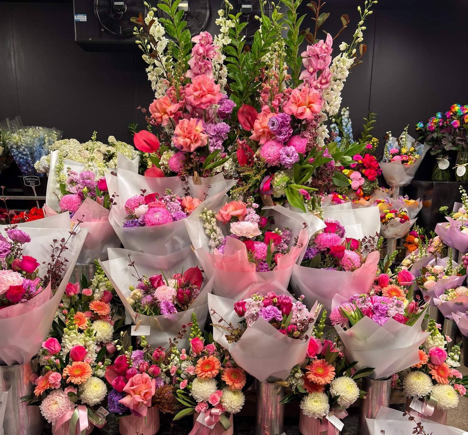 Bouquets of flowers arranged in a display setting with a dark background.